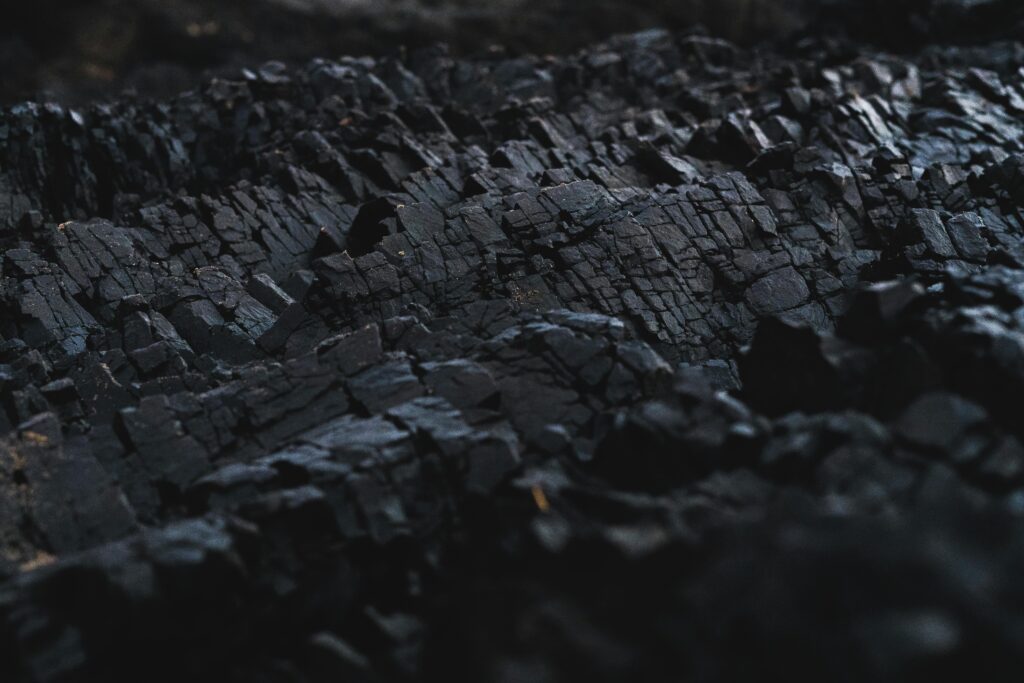 A detailed close-up of dark charcoal texture, showcasing its rough and jagged surface.