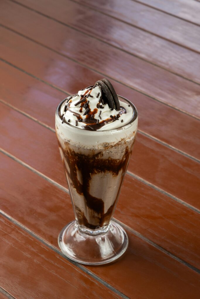 Indulge in a creamy chocolate milkshake topped with whipped cream and an Oreo.